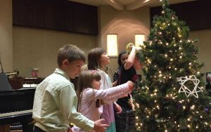 children decorate a Christmas tree